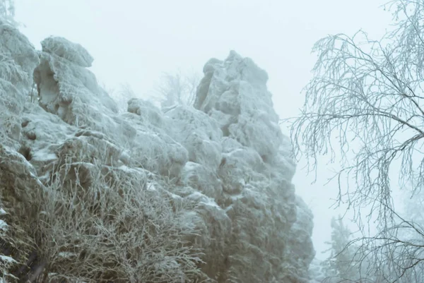 Celowo Niewyraźne Tło Piękny Pokryte Śniegiem Skały Nad Lasem Zimą — Zdjęcie stockowe