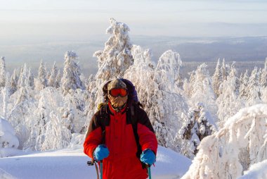 Gezgin Kayak Polonyalılar ile windproof maskeli bir kış kar orman arasında bir tepe üzerinde duruyor