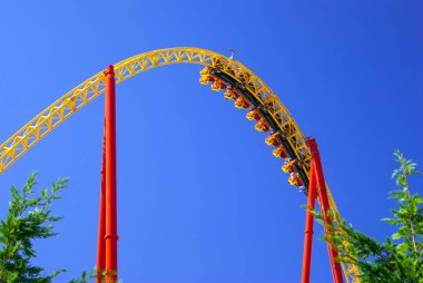 arabaları mavi gökyüzüne karşı baş aşağı geçirilmesi sırasında roller coaster üzerinde döngü bir parçası