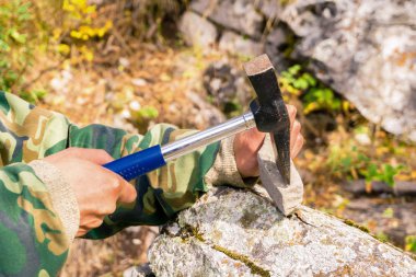 eller bir jeolog mineralojik örnek jeolojik bir çekiç ile bölme
