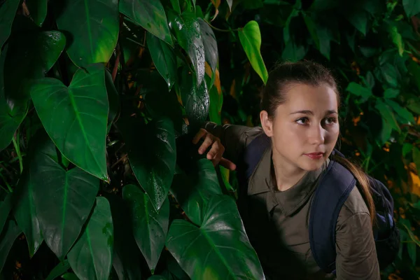 girl traveler walks in the jungle amidst tropical vegetation