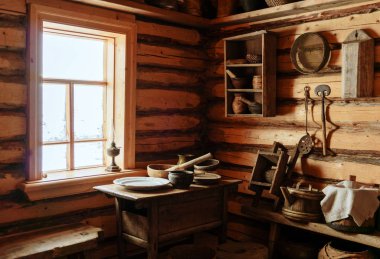fragment of the interior of an old peasant log cabin - a table with wooden and ceramic dishes, a kerosene lamp clipart