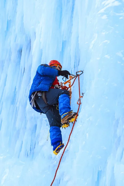 Eiskletterer Erklimmt Bei Schneefall Eine Senkrechte Blaue Eiswand — Stockfoto