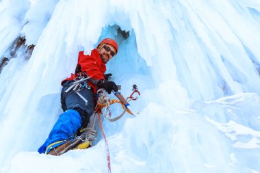 buz tırmanıcı bir donmuş şelale büyük buz sarkıtları arasında dikey bir duvara