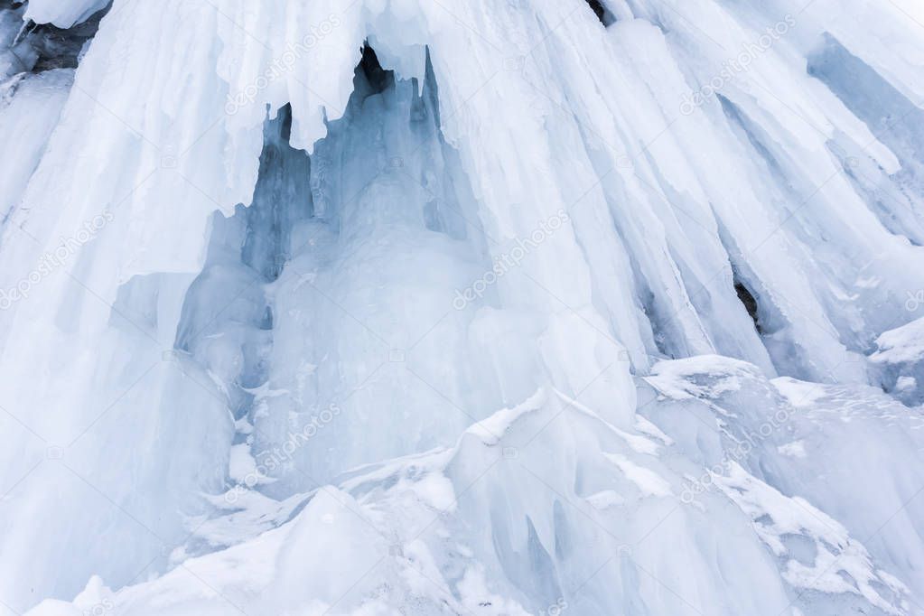 background - fragment of glacier with draperies of icicles, entrance to ice cave