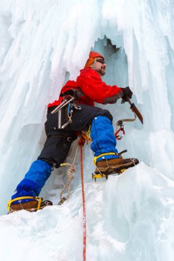 buz tırmanıcı bir donmuş şelale büyük buz sarkıtları arasında dikey bir duvara