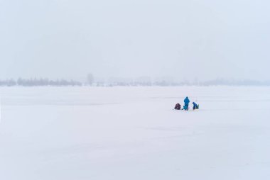 Uzaktan üç balıkçı balıkçılık sisli karlı kış manzara içinde buz