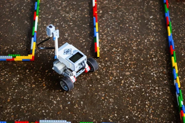 small real programmable robot on wheels moves through an artificial labyrinth