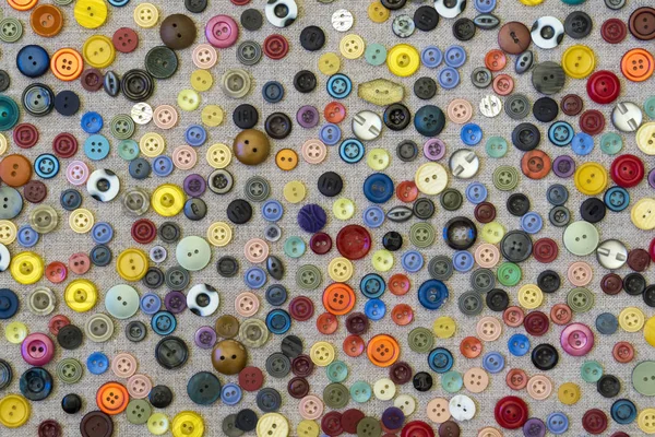 Фон - разноцветные кнопки на грубом холсте — стоковое фото