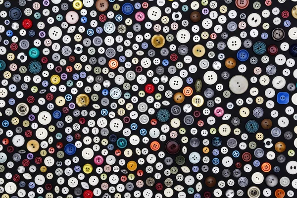 Fondo - botones multicolores en una superficie oscura — Foto de Stock