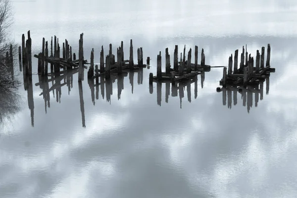 Hermoso paisaje acuático con fragmentos de pilas de la antigua bri — Foto de Stock