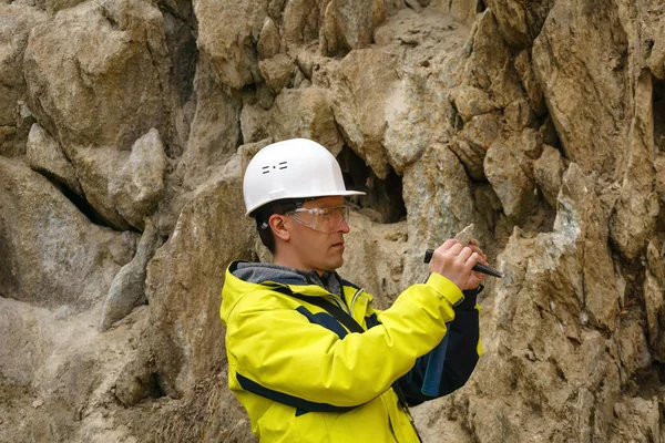Geólogo examina uma amostra de pedra ao ar livre — Fotografia de Stock