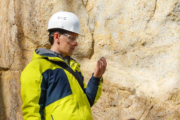 Geólogo examina uma amostra de pedra ao ar livre — Fotografia de Stock