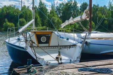 küçük yatlar ahşap bir iskelede demirlemiş