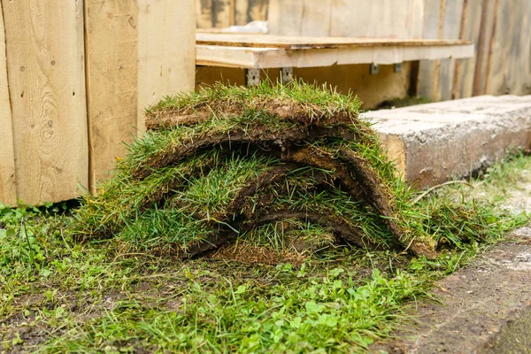 Pieces of turf on the background of wooden structures — Stock Photo, Image