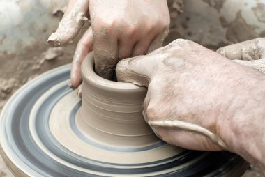 iki çift el çömlekçi tekerleğinde kilden bir şey kalıba