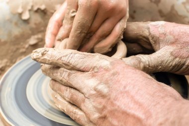 iki çift el çömlekçi tekerleğinde kilden bir şey kalıba