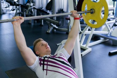 Genç adam halter Bench Press gerçekleştirir