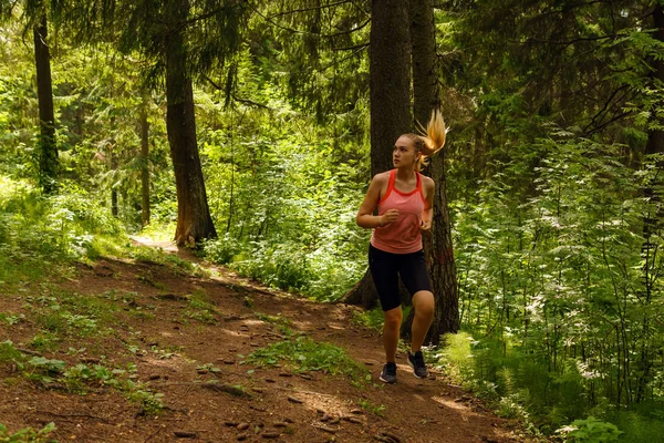 Jonge vrouw joggen in een berg woud — Stockfoto