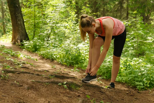 Nő megállt jogging egy hegyi erdő nyakkendő cipőfűző — Stock Fotó