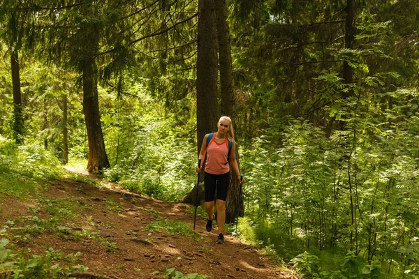 Jonge vrouw trekking in een berg woud — Stockfoto