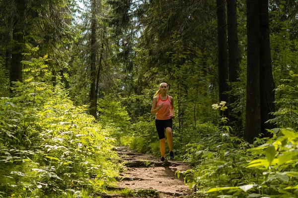 Jonge vrouw joggen in een berg woud — Stockfoto