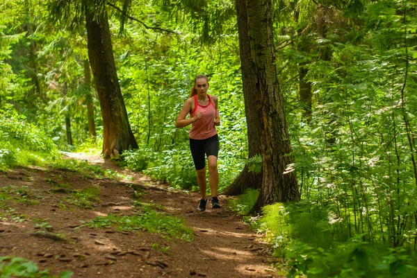 Jonge vrouw joggen in een berg woud — Stockfoto