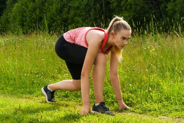 Jeune femme en position de départ bas avant de faire du jogging dans le parc — Photo