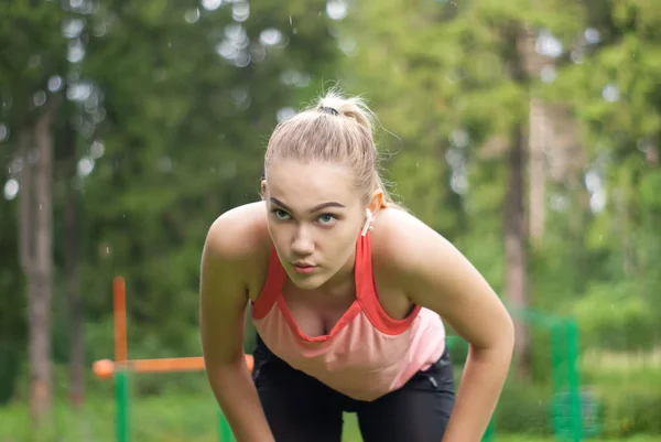 young woman taking a break while doing sports outdoors