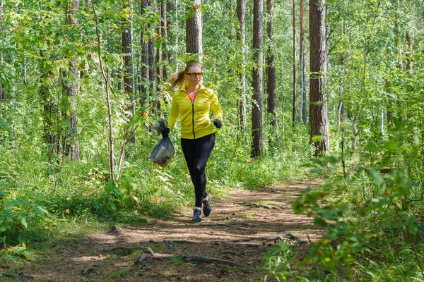 Jovem mulher plogging no parque — Fotografia de Stock