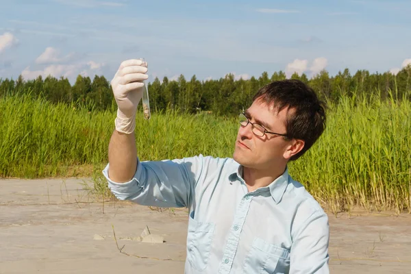 Homem ecologista ou biólogo examina amostra de solo in vitro — Fotografia de Stock