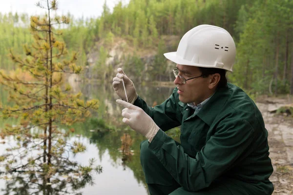 Industrieökologe entnimmt eine Wasserprobe aus einem überfluteten Quar — Stockfoto