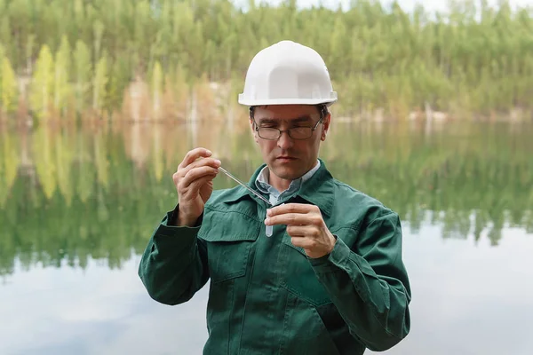 Ecologista industrial toma una muestra de agua del lago en el si — Foto de Stock