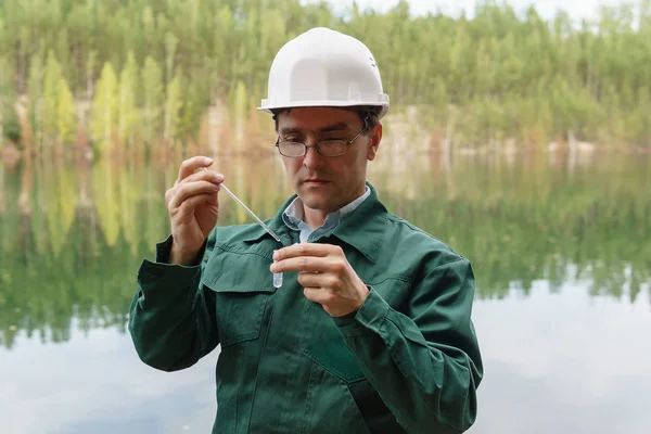 Ecologista industrial toma una muestra de agua del lago en el si — Foto de Stock