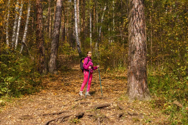 Vrouw trekking in het herfst bos — Stockfoto