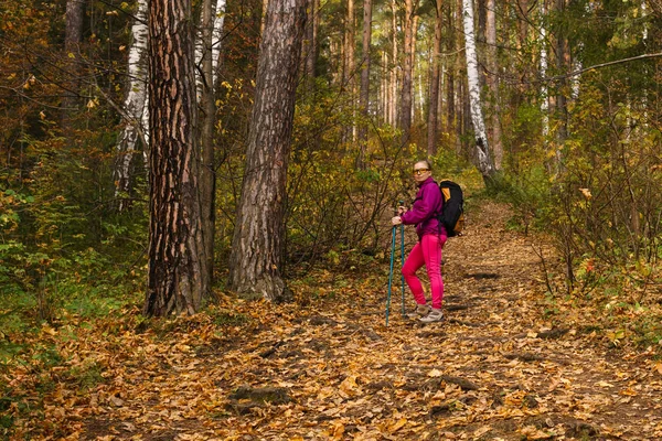 Vrouw trekking in het herfst bos — Stockfoto