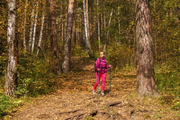 Vrouw trekking in het herfst bos — Stockfoto