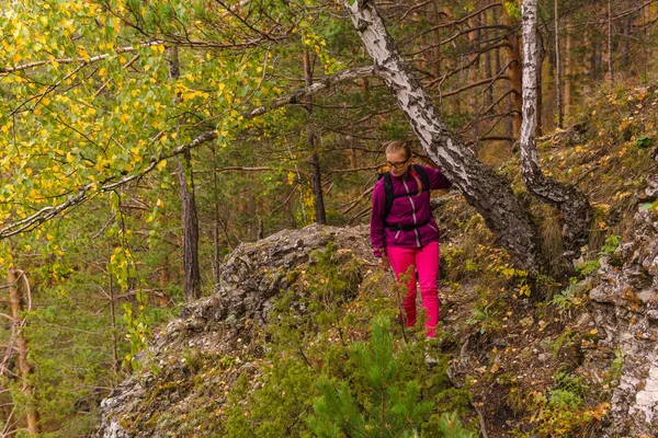 Vrouwelijke wandelaar trekking in het herfst bos — Stockfoto