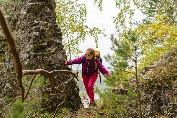 Jovem mulher com mochila trekking em uma trilha de montanha — Fotografia de Stock