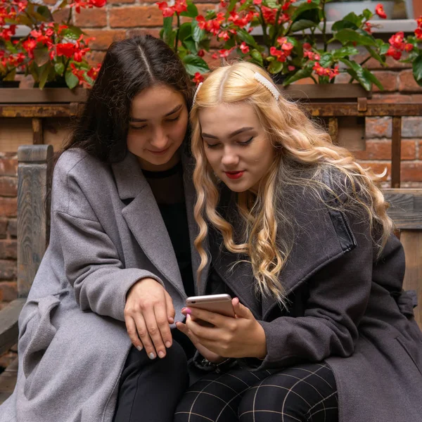Dos novias discutiendo algo mientras miran en un smartp — Foto de Stock