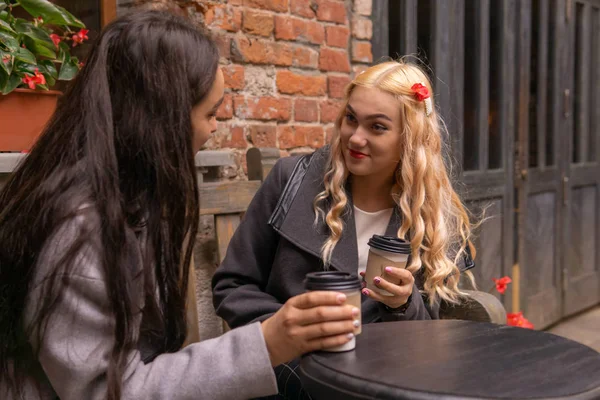 Chica en sorpresa escucha a su amigo en un banco con café ou — Foto de Stock