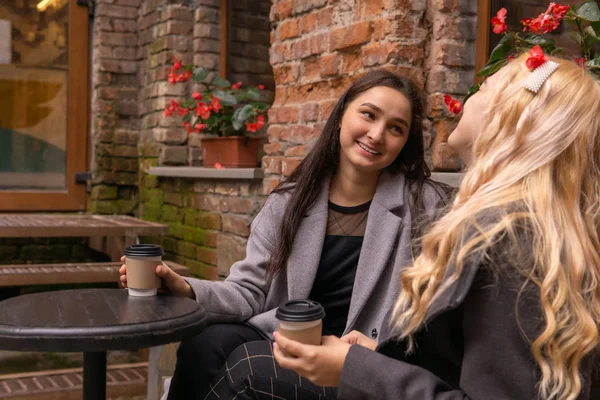 Chica está teniendo una conversación divertida con su amigo durante el café ou — Foto de Stock