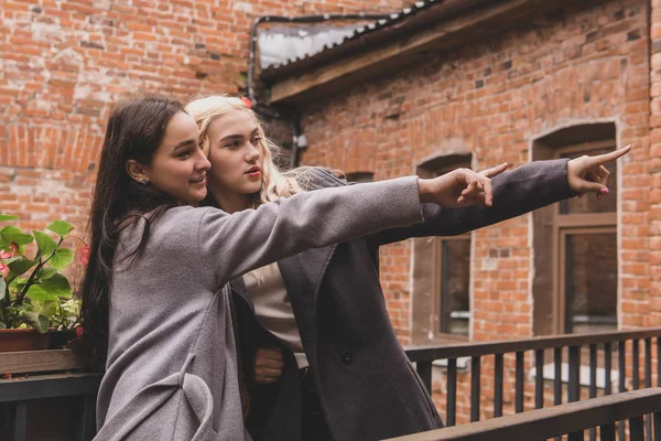Duas garotas no pátio de um prédio antigo se mostram no — Fotografia de Stock