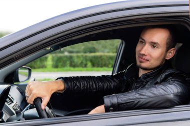 bir şehir caddesinde bir arabada genç adam