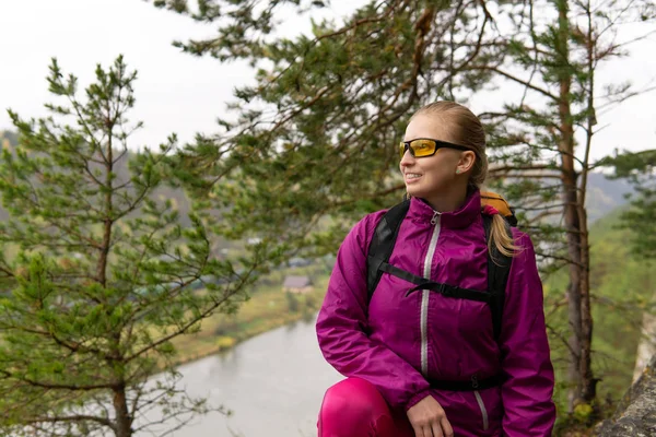 Portret van een vrouwelijke toerist op een klif boven een riviervallei — Stockfoto