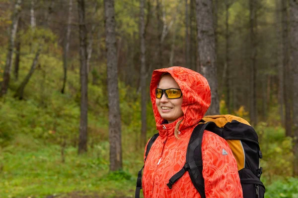 Glimlachende vrouwelijke wandelaar in het herfstbos — Stockfoto