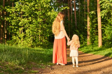 Anne ve küçük kızı akşam parkında yürüyorlar, Bac 'ın manzarası