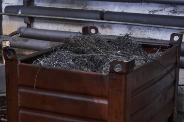 Çeşitli metal talaşlarıyla dolu bir kutu. Üretimi durduran atıklar.