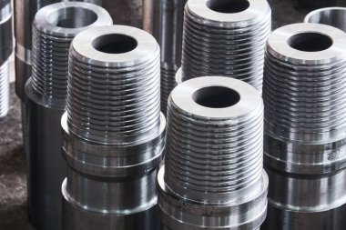 Endüstriyel arka plan - yeni parlak çelik donanım, çeşitli çaplı turbo matkapların parçaları bir atölyenin zemininde