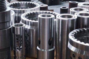 Endüstriyel arka plan - yeni parlak çelik donanım, çeşitli çaplı turbo matkapların parçaları bir çalışma alanında yerde.